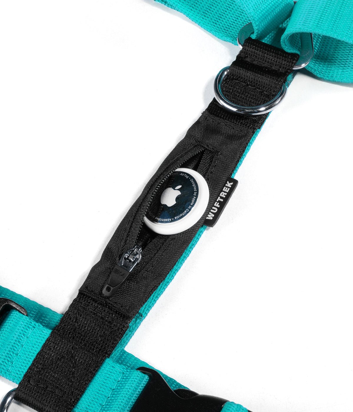 Detalle de un AirTag de Apple saliendo del bolsillo de un arnés H para perros color azul turquesa con negro
