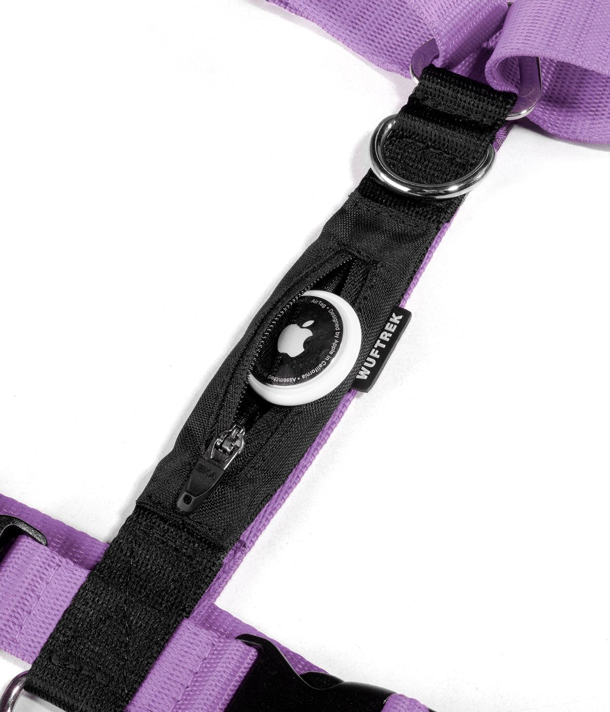 Detalle de un AirTag de Apple saliendo del bolsillo de un arnés H para perros color lila con negro