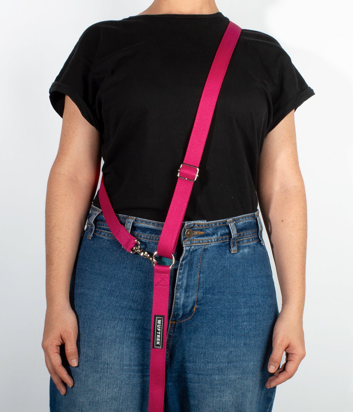 Una mujer usando una correa manos libres para perros color fucsia