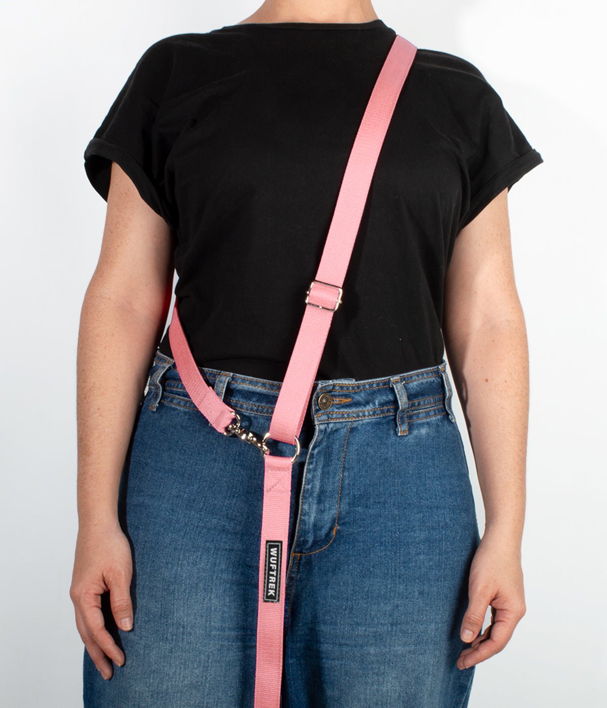 Una mujer usando una correa manos libres para perros color rosa