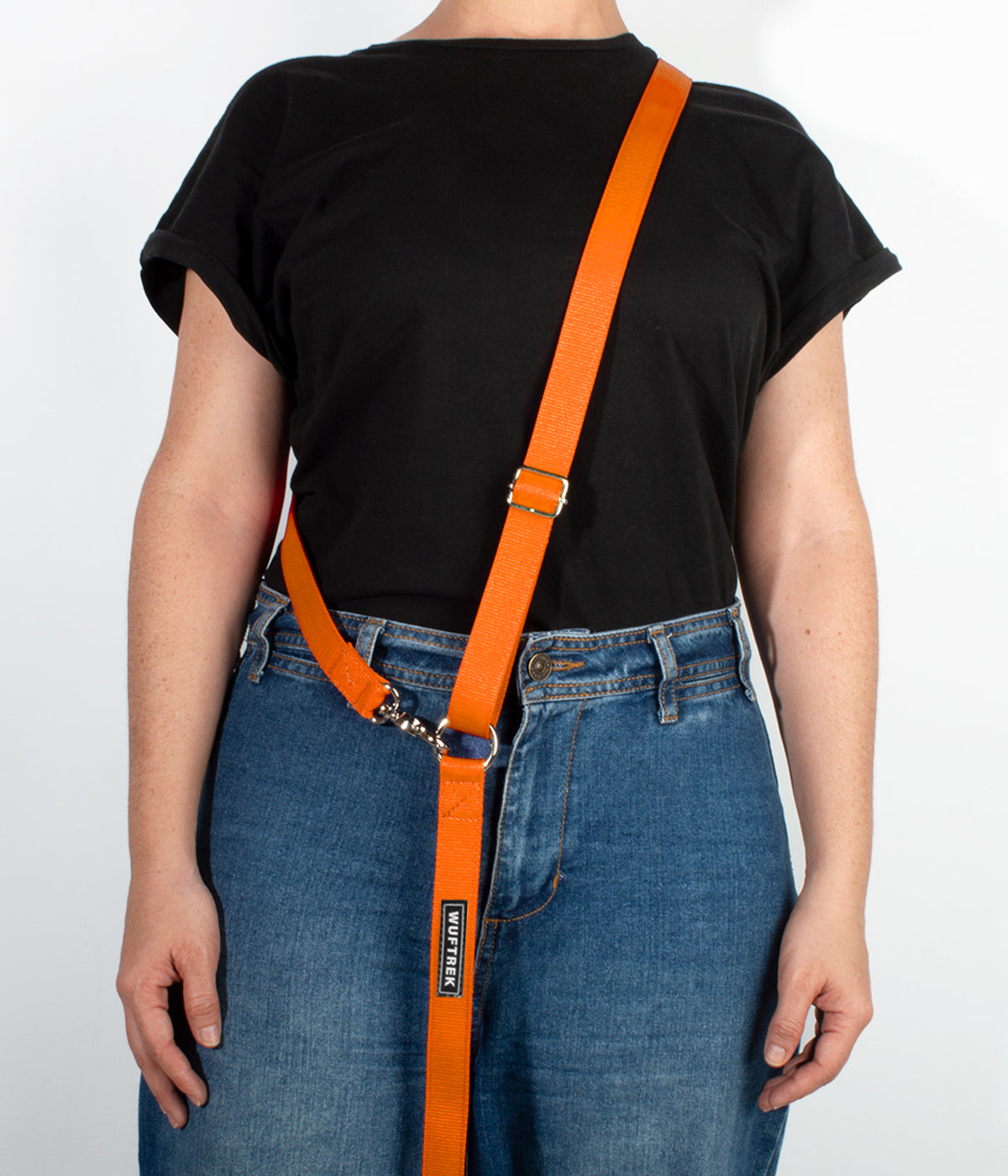 Una mujer usando una correa manos libres para perros color naranja#color_naranja
