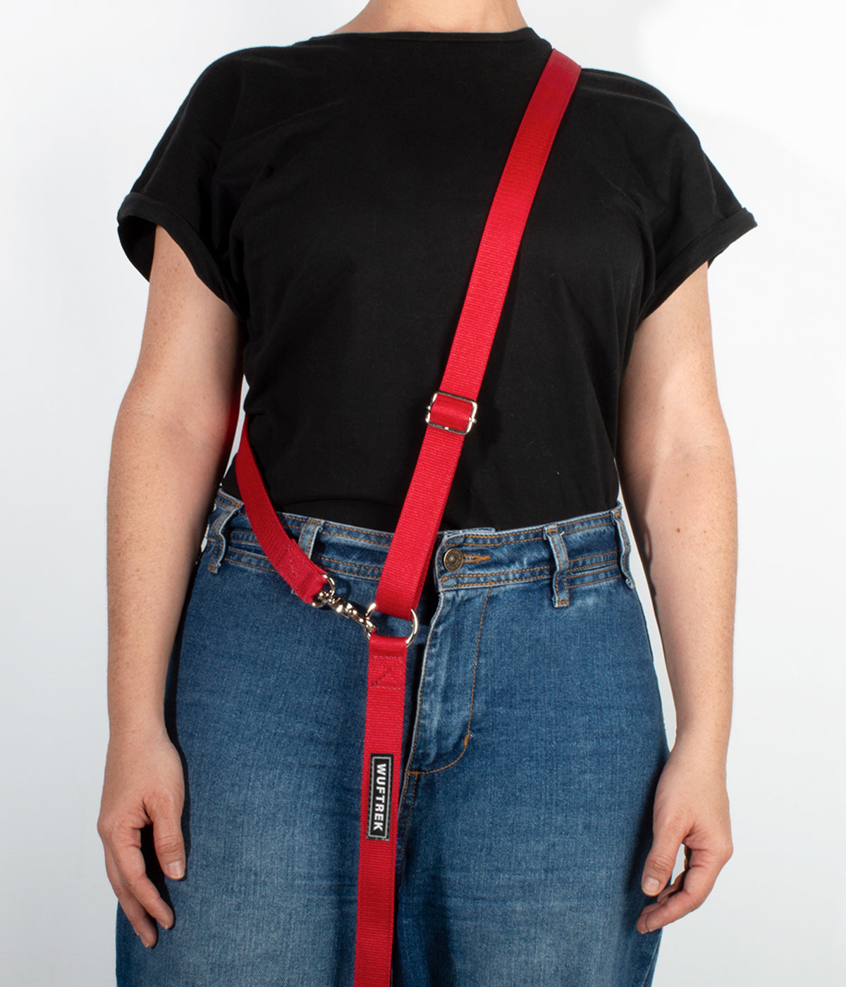 Una mujer usando una correa manos libres para perros color rojo