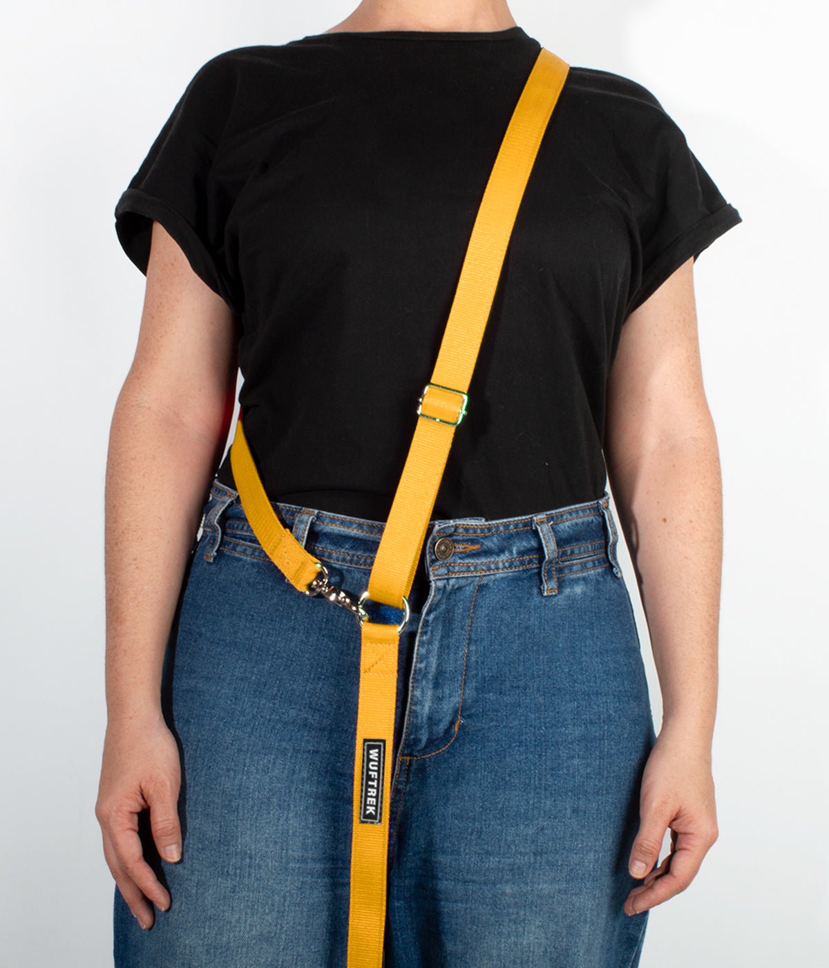 Una mujer usando una correa manos libres para perros color amarillo