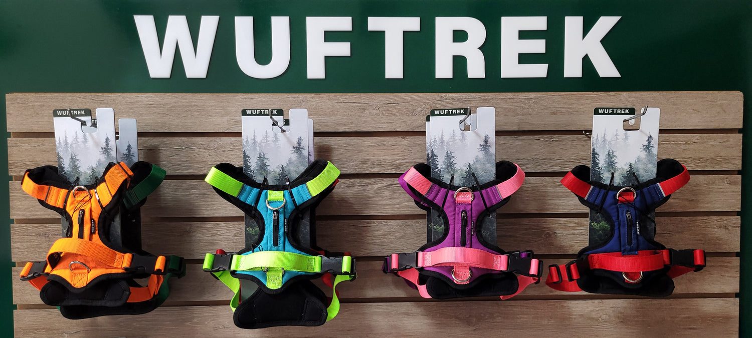 Un exhibidor con arneses para perros de diferentes colores