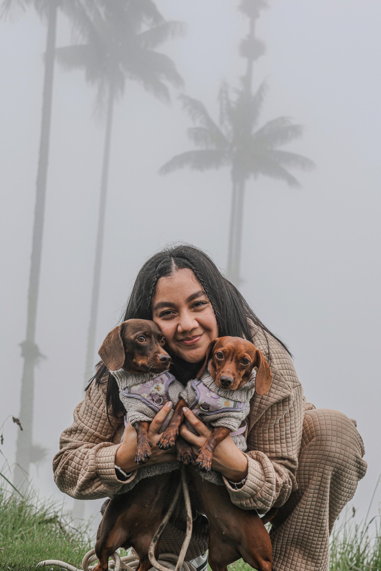 Una mujer abrazando a dos perros