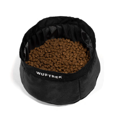 Un nomedero para perro color negro con comida para perros en su interior