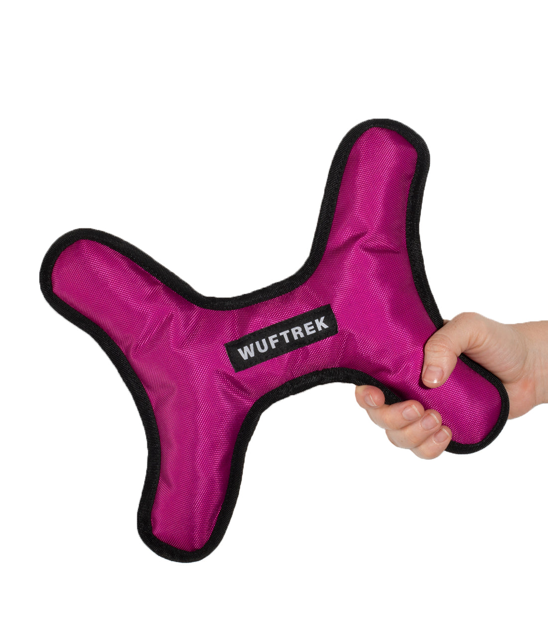Una mujer sujetando un juguete para perro en forma de hueso grande en color violeta