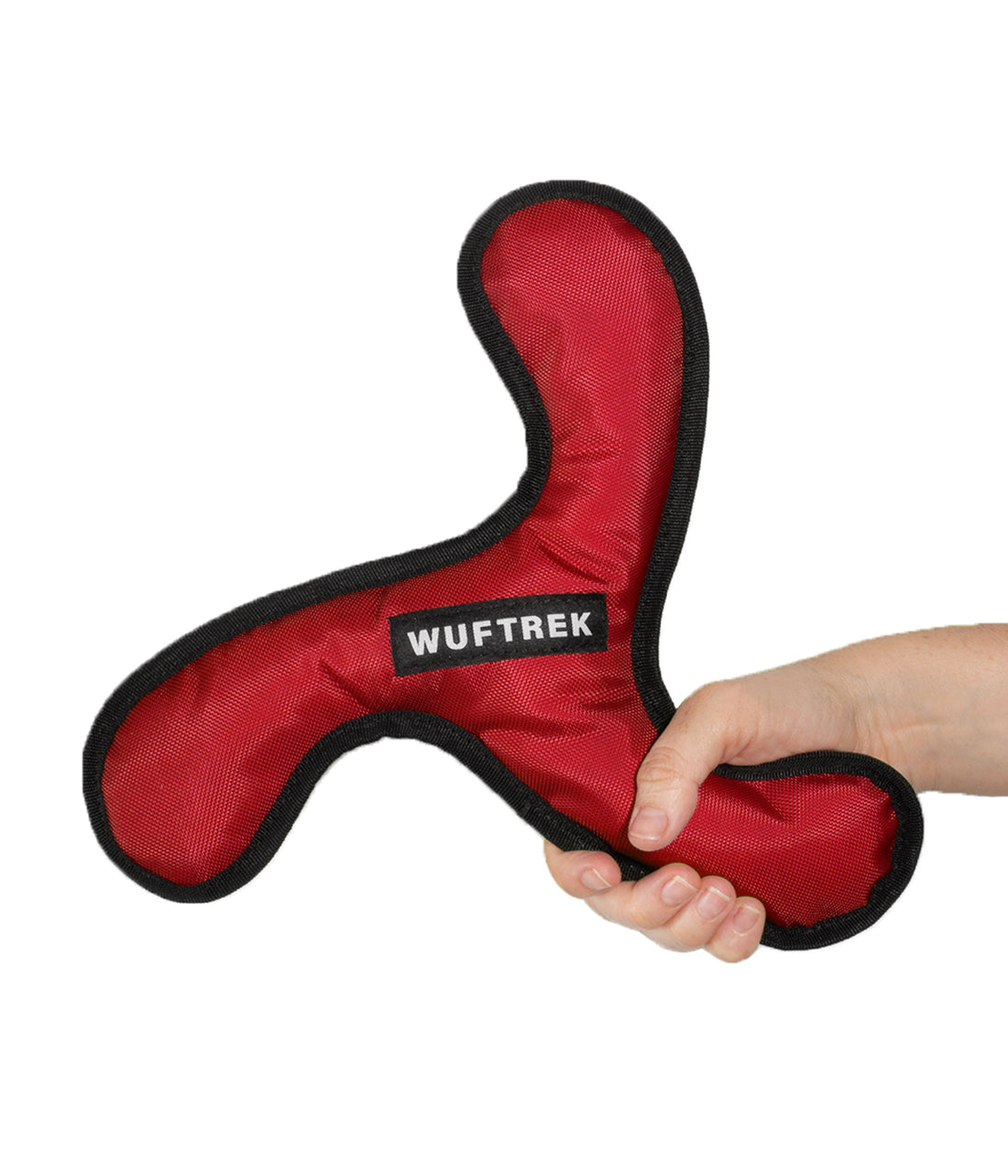 Una mujer sujetando un juguete para perro en forma de espiral  en color rojo