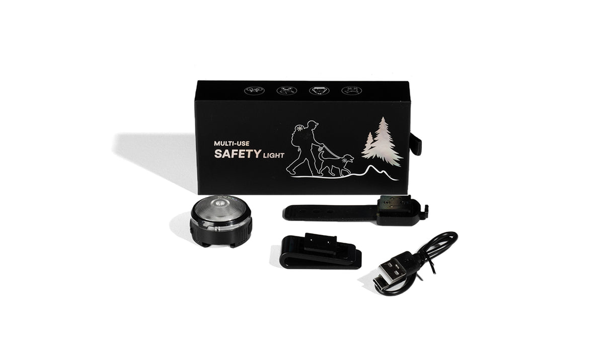 Un kit de luz led donde se ve la caja negra, con la luz, una correa en plastico para amarrar, un clip para ajustar y un cable de carga USB