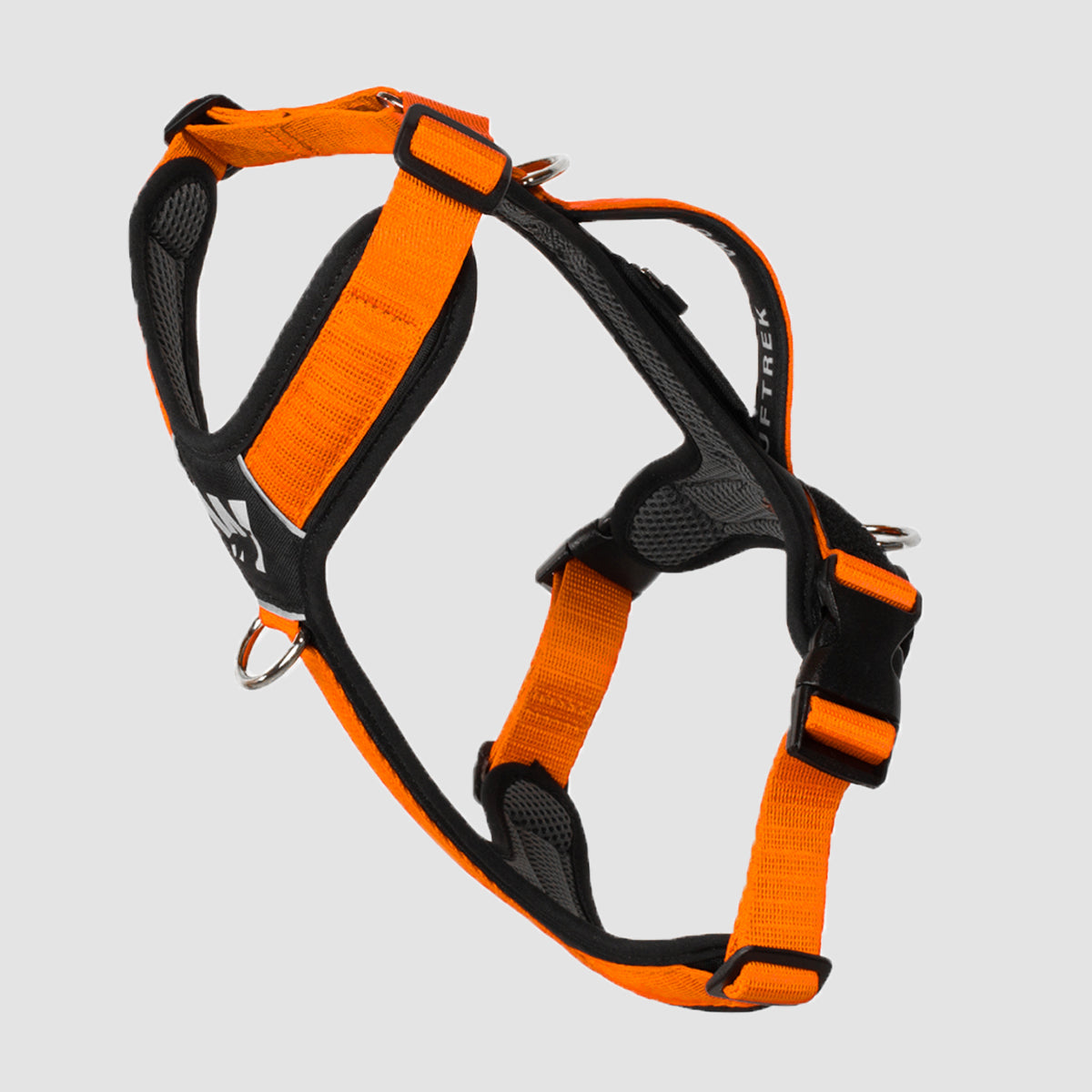 Un Arnes en forma de Y en color naranja con negro, visto de lado, se puede observar la manija de control, las argollas de atras, las tiras ajustables y la argolla anti tirones