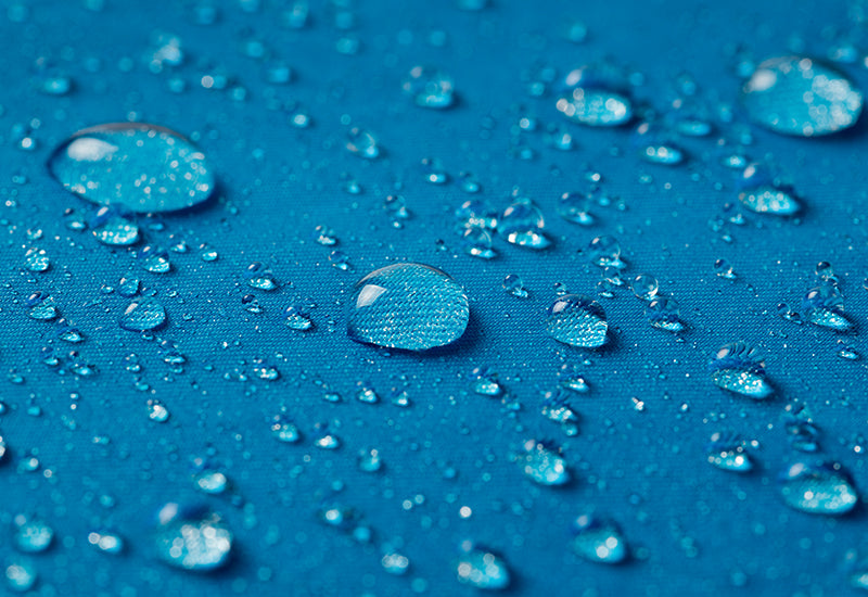 Textil con tecnología resistencia al agua en color azul con gotas de agua en la superficie